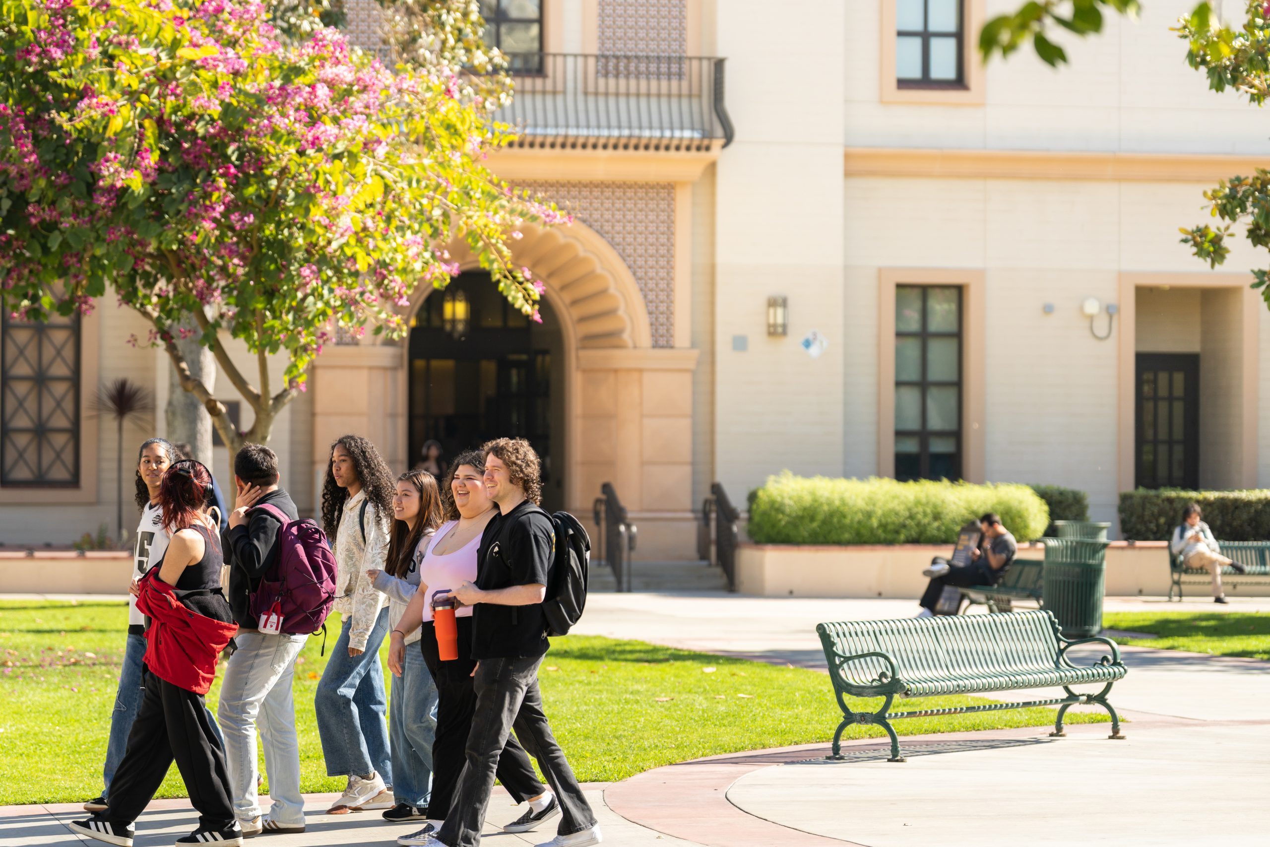 Photo of a group of Fullerton College students walking around the quad and talking together.